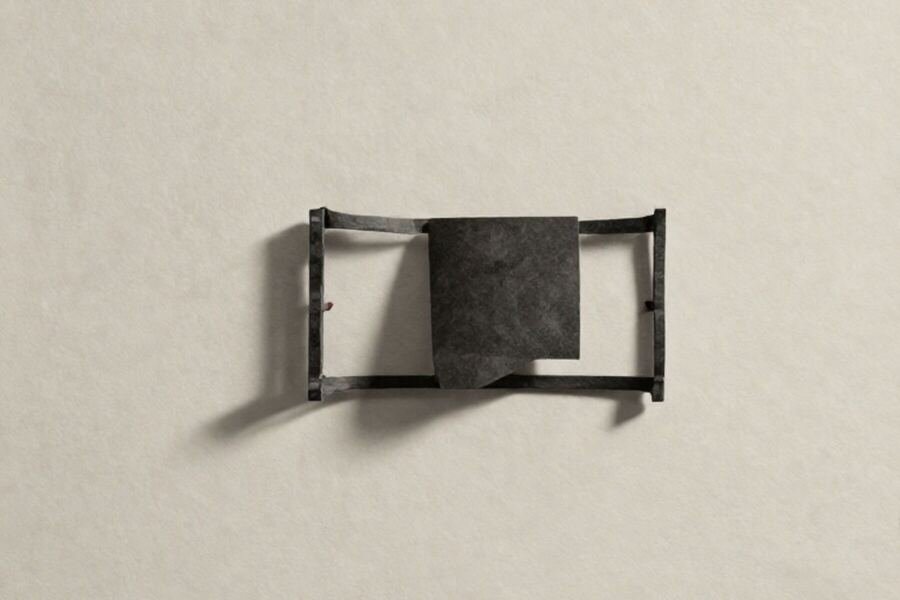 A solid paper form held inside a large open bracket cut from card