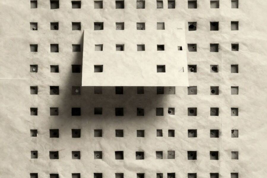 A rigid grid of paper cells with one cell lifted forward