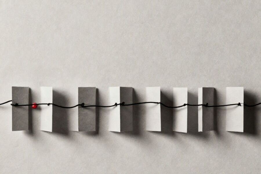 A row of identical paper markers threaded onto a single taut line