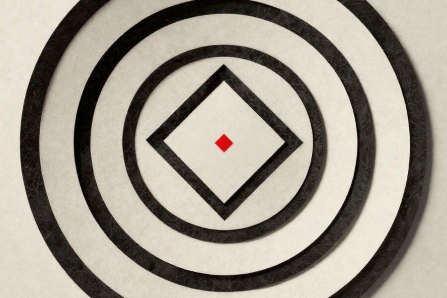 Concentric paper rings laid around a single small square at the centre