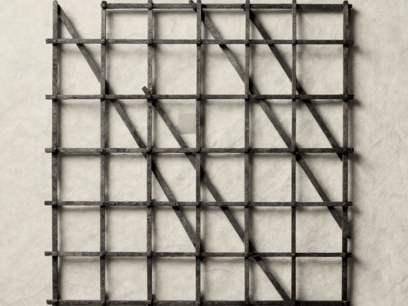 A lattice of thin dark rods laid over pale paper, with one cell filled solid